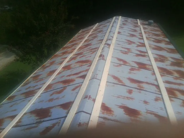 Rusted metal roof panels with new wood purlins before replacement — Storm Damage Roof Repair in Iron Gate by Roofing Brothers